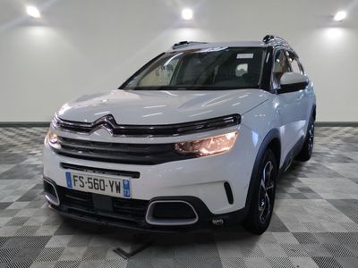 Le SUV Citrole blanc est garé dans une grande pièce.