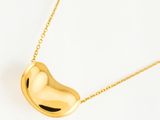 un pendentif en or en forme de cœur, monté sur une chaîne en or