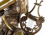 bronze statue of a woman playing a lyre with a musical instrument