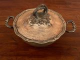 a silver bowl with a handle on a wooden table