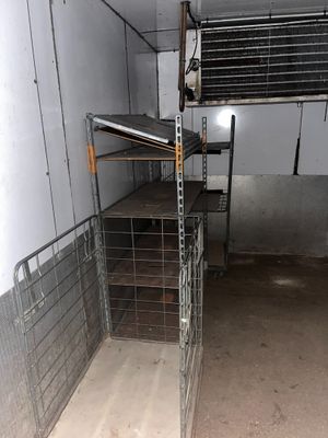 a metal cage with shelves in the middle of a room