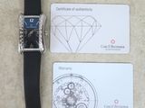 une montre et une carte de visite posées sur une table