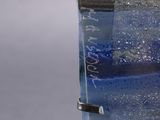 a close up of a glass sculpture of a boat on a body of water