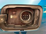a close up of a car ' s fuel pump with a blue car in the background