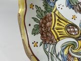 a decorative plate with flowers on it sitting on a table