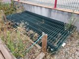 a metal grate on the ground next to a fence