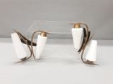 deux vases blancs rehaussés de touches dorées, posés sur une surface transparente