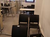 de nombreuses chaises et tables dans une pièce où se trouvent de nombreux bureaux