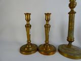 three brass candlesticks sitting on a white surface