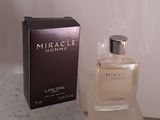 l'image d'un flacon de parfum à côté d'une boîte