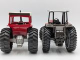 two toy tractors that are sitting side by side on a white surface