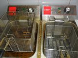 two deep fryers that are sitting on a counter