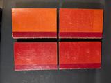 four pieces of red and orange soap sitting on top of a black counter