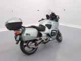 a blue motorcycle parked in a room with a white wall