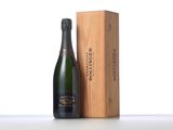 a bottle of champagne next to a wooden box on a table