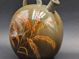 a vase with a painting on it sitting on a table