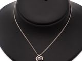 a black necklace with a silver pendant on a black mannequin