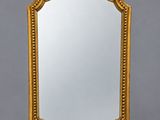 un miroir à cadre doré orné d'un motif décoratif sur le pourtour