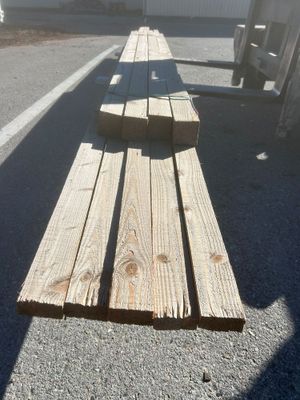 plusieurs morceaux de bois sont empilés sur un parking