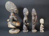 three figurines of different shapes and sizes on a black background