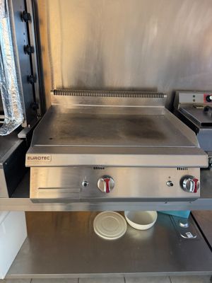 un plan de travail en acier inoxydable muni de deux éviers dans une cuisine professionnelle