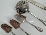 five spoons, a knife, and a spoon on a cutting board