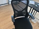 a black office chair sitting in front of a computer desk