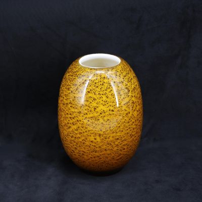 une image représentant un vase jaune sur fond noir