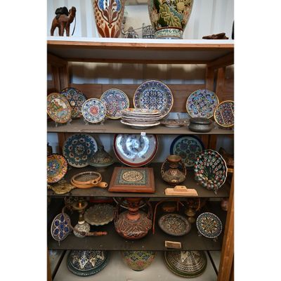 de nombreuses assiettes et vases posés sur une étagère dans une pièce
