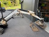a small excavator that is parked in front of a building