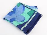 a blue and green floral pocketed handkerchief on a white surface