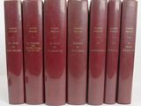 six livres rouges alignés sur une surface blanche