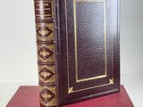 an old book sitting on top of a red book case