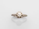une bague de fiançailles avec un diamant au centre, sur fond blanc