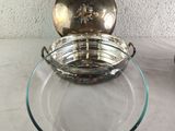 a glass bowl with a metal lid sitting on a glass plate