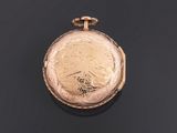 an old gold pocket watch with a chain on a black surface