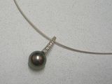collier en métal argenté orné d'une perle noire et d'un pendentif en diamant