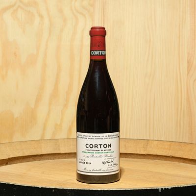 a bottle of wine sitting on top of a barrel