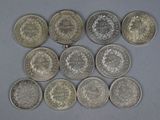 six different types of silver coins are arranged in a triangle