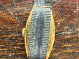 a close up of a watch on a wooden table