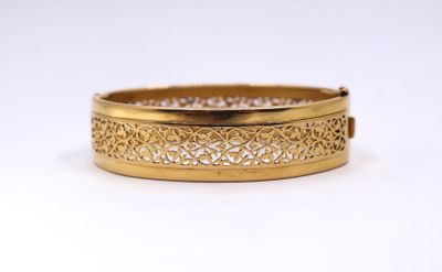 a close up of a gold bracelet on a white background