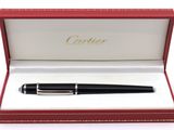 un stylo noir dans une boîte rouge sur fond blanc