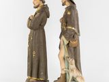 a pair of antique figurines of two men and a dog