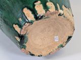 a close up of a green vase on a white surface