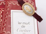 a red book with a gold watch on top of it and a red book with a gold watch on top of it