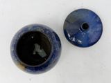 pair of blue and black vases sitting on a white surface