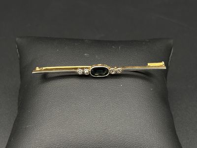 une image représentant une broche en forme de diamant noir et de lingot d'or