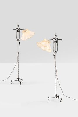 a pair of floor lamps with lampshads on each of them
