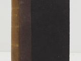 a brown and black book sitting on top of a white table