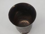 a metal cup that is sitting on a table